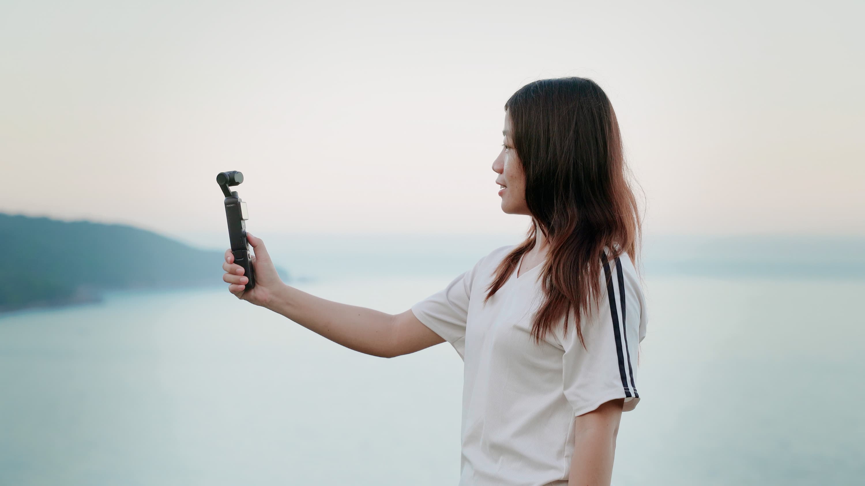 Xuân quay video bằng máy quay cầm tay khi hoàng hôn buông trên mặt nước